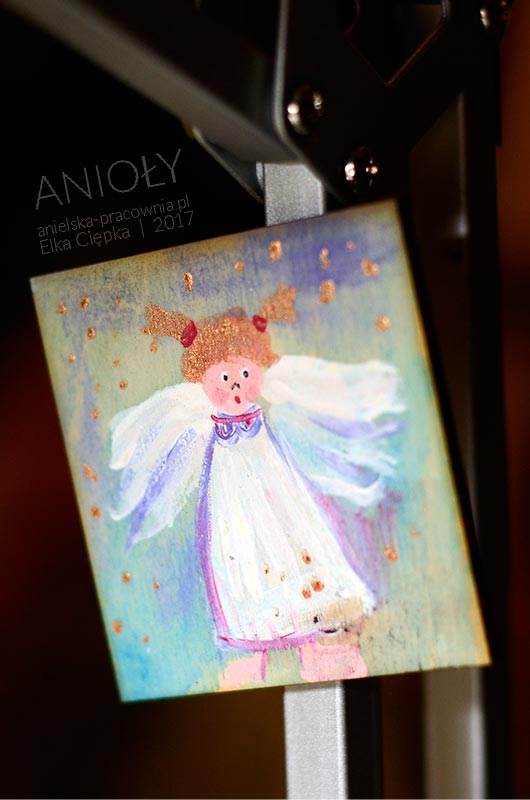 Drobny upominek w formie magnesu na lodówkę z aniołkiem ręcznie malowanym na sklejce brzozowej
